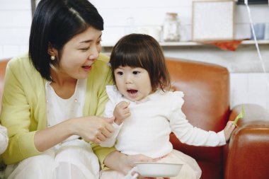 Anne ve küçük kızı evde oynuyorlar.