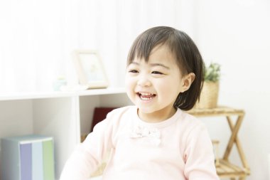 Asyalı küçük kız evde oynuyor.