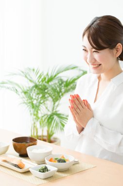 Yemek yemeden önce ellerini masaya koyan kadın. 