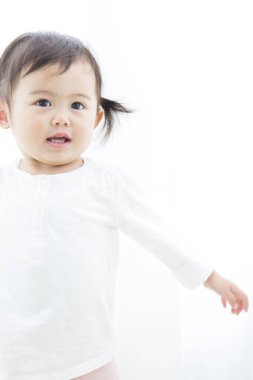 Asyalı küçük kız evde gülümsüyor. 