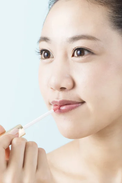 唇の光沢を適用する若い美しいアジアの女性 — ストック写真