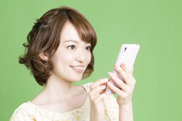 Портрет Красивої Японської Жінки Використовує Смартфон Зеленому Фоні — стокове фото
