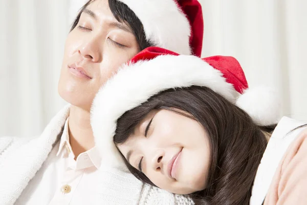 Noel Baba Şapkalı Genç Çift Oturuyor Uyuyor — Stok fotoğraf