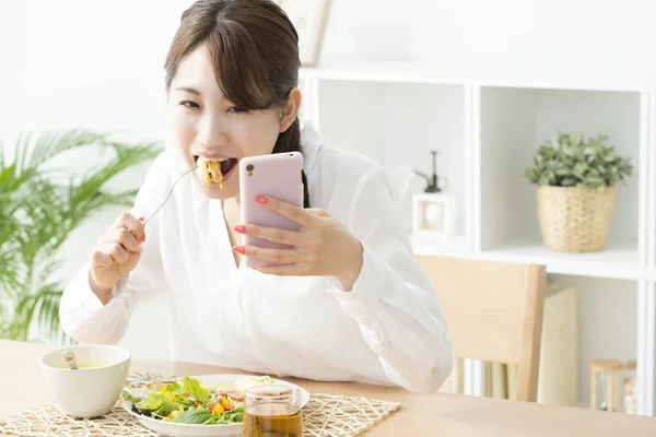 Beautiful Asian Woman Using Smartphone While Eating — Stock Photo, Image