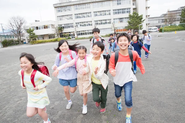 Grupo Niños Japoneses Con Mochilas Corriendo Patio Escuela —  Fotos de Stock