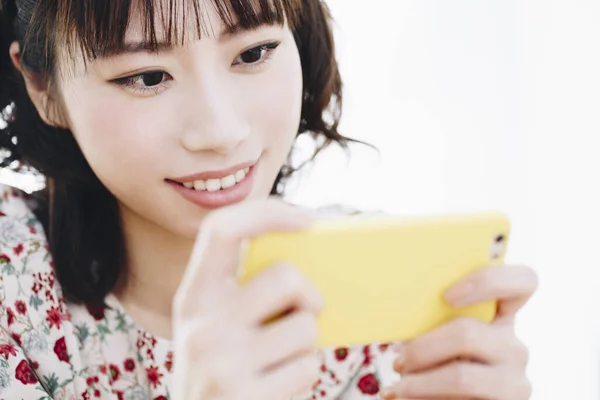 Portret Uśmiechniętej Młodej Azjatki Korzystającej Smartfona — Zdjęcie stockowe