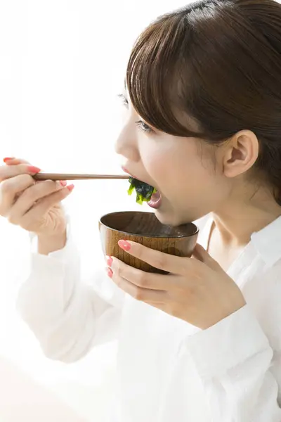 年轻的日本女人用筷子吃饭 — 图库照片
