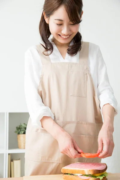 Krásná Asijská Žena Dělat Chutné Sendvič Kuchyni Stůl — Stock fotografie