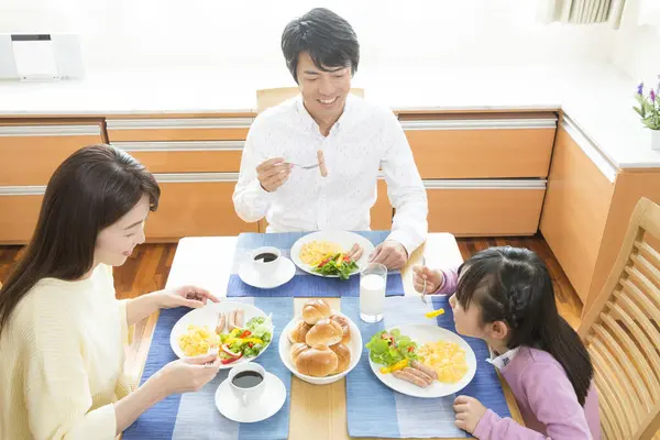 キッチンで一緒に朝食を持っている幸せなアジアの家族 — ストック写真