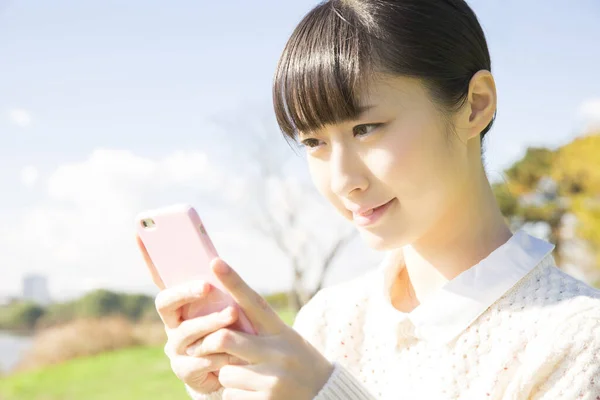 日本女孩在户外带智能手机的肖像 — 图库照片