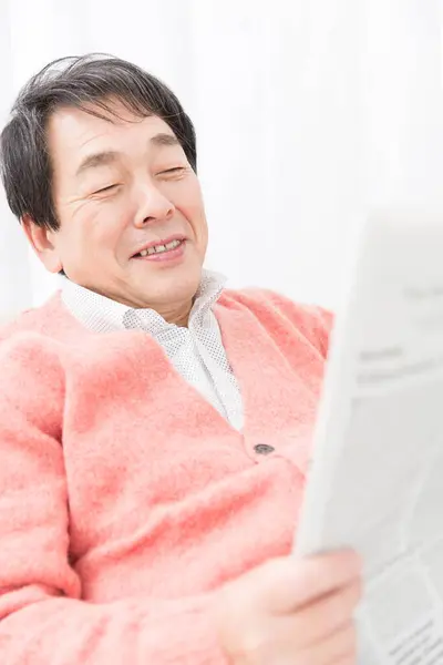 asian man reading a newspaper