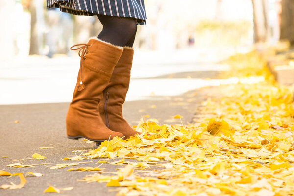 Девушка с желтыми листьями клена в осеннем парке.