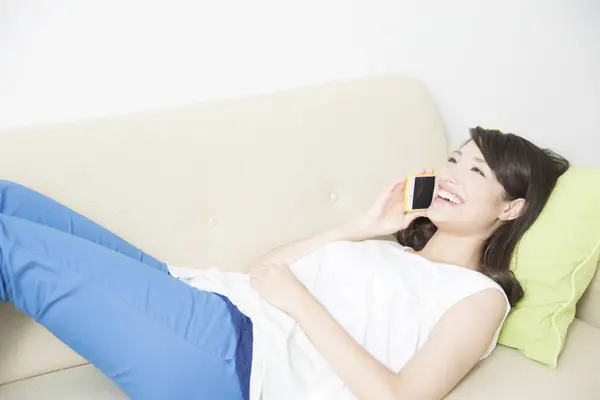 asian woman with smartphone  on sofa