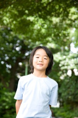 Yaz parkındaki genç Japon çocuğun portresi.