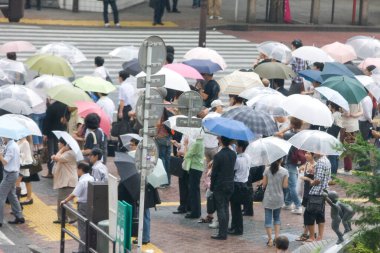 Yağmurlu bir günde sokakta şemsiyeli bir kalabalık.