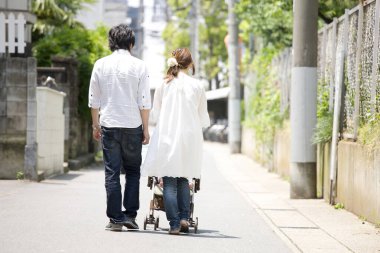 Bebek arabalı Asyalı kadın ve erkek.