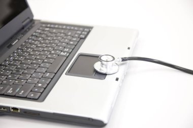 Beyaz arkaplanda steteskobu olan dizüstü bilgisayar             