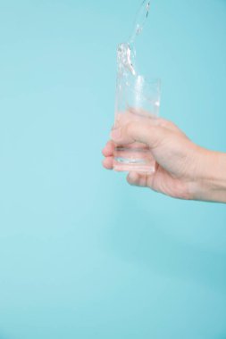 Renkli arka planda bir bardak su tutan kadın