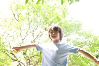 Yaz parkındaki genç Japon çocuğun portresi.