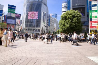 Tokyo caddesinde yürüyen insanların bulanık görüntüsü