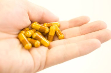 beyaz zemin üzerinde elinde haplar