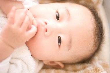 Asyalı bebek yatakta yatıyor..