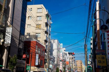Gölgeler ve dokular, parlak Japon yolu boyunca mimarinin görüntüsüne derinlik katar..