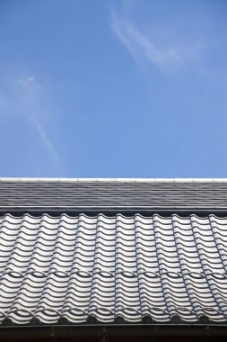 Mavi gökyüzü arka planına sahip çatı kiremitlerinin düşük açılı görünümü 