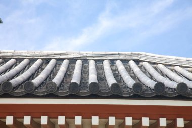 Mavi gökyüzü arka planına sahip çatı kiremitlerinin düşük açılı görünümü 