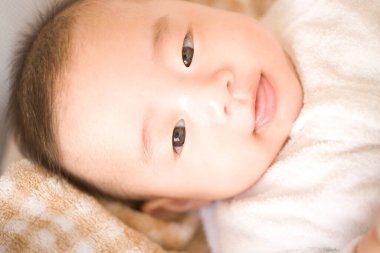 Yatakta sevimli Asyalı bebek