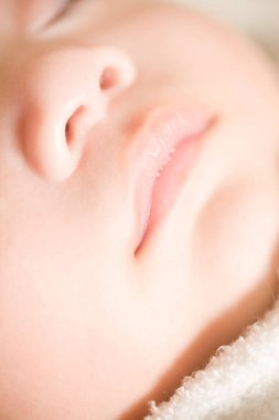 Yeni doğmuş bebek yatakta uyuyor.