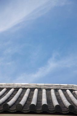 Mavi gökyüzü arka planına sahip çatı kiremitlerinin düşük açılı görünümü 