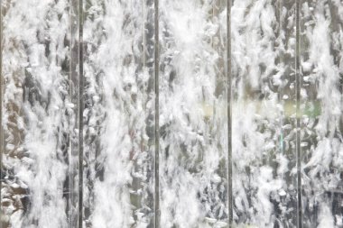 Su kadehten aşağı dökülüyor ve güzel bir doku oluşturuyor.