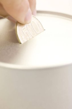 Gümüş sikke tutan genç bir kadının eli