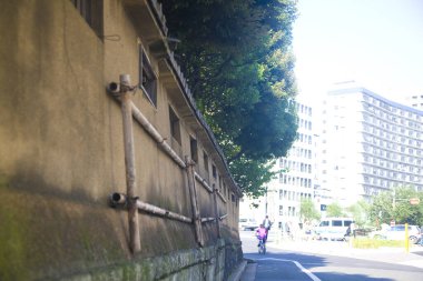 Sokak manzarası Tokyo 'daki duvar ve binaları gösteriyor.