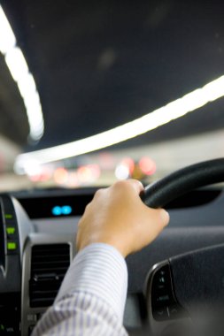 Adamın elleri direksiyon simidini tutuyor.