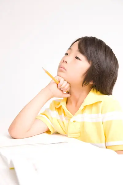 アジアの少年は白い背景で勉強しています — ストック写真