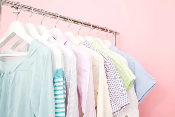 Bunte Kleidung Auf Kleiderbügeln Vor Farbigem Hintergrund — Stockfoto