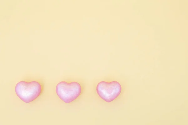 黄色の背景にある3つのピンクのハート — ストック写真