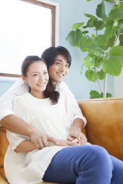 Genç çift evdeki kanepede oturuyor.