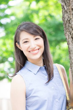 Parkta çantalı genç bir kadın. 