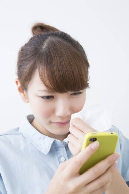 Genç Asyalı kadın cep telefonu kullanıyor.