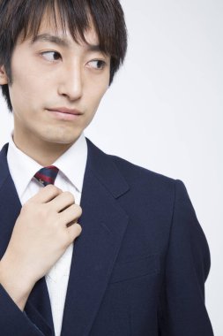 Beyaz arka planda takım elbiseli genç Asyalı iş adamı