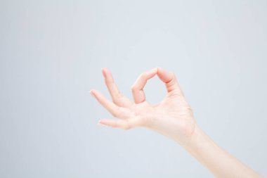 Beyaz arka planda el hareketi yapan kadınların yakın çekimi. 