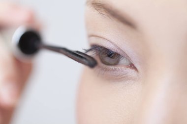 Genç Asyalı kadının rimel sürüşünü yakından izle