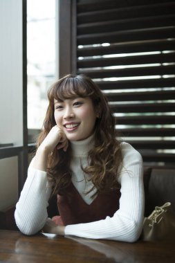 Kafede oturan genç ve güzel bir Japon kadın.