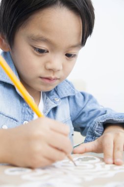 Evdeki kağıda resim çizen sevimli küçük çocuk.