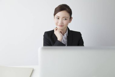 Dizüstü bilgisayar kullanan kendine güvenen Japon iş kadını.