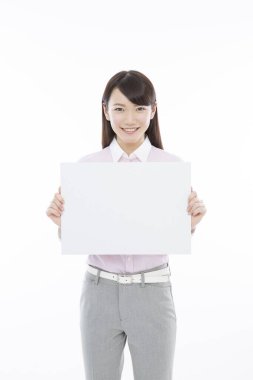 Tecrit edilmiş arka planda boş tahtası olan genç Asyalı iş kadını. 