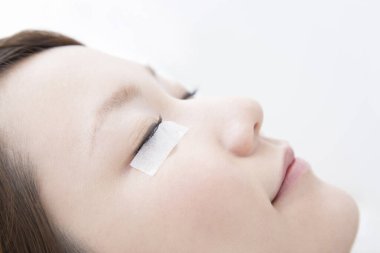 Kirpik uzatma işlemi yapan kadın, yakın plan.